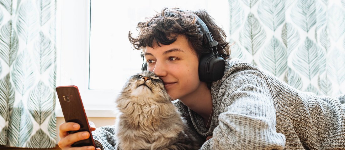 ZOO & Co. Newsletter - Kind mit Katze informieren sich via Handy über aktuelle Angebote